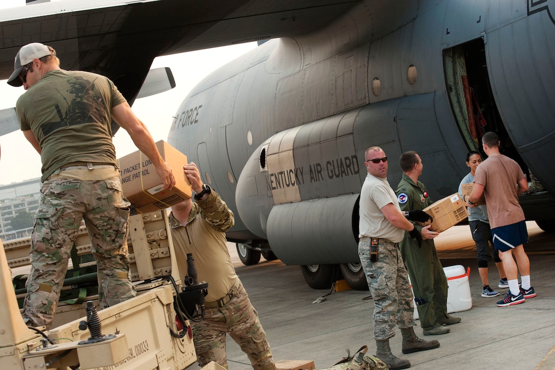 Airmen pack food and equipment aboard a Air National Guard C-130 Hercules