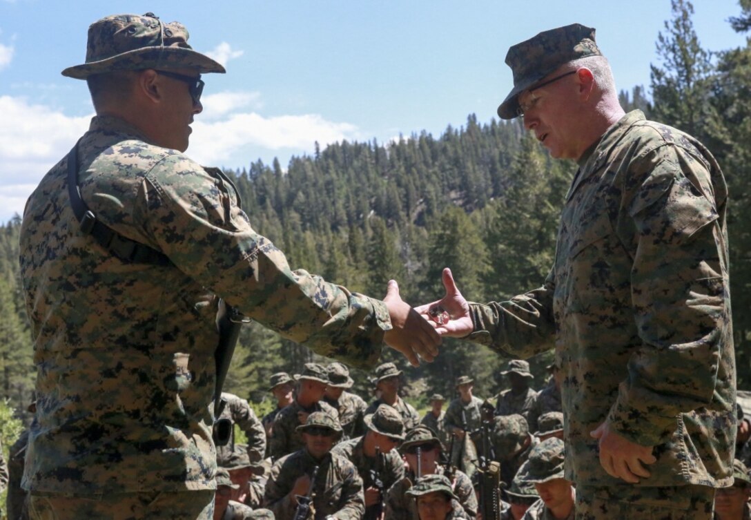 Col. David Owen, the Marine Expeditionary Force Information Group Commanding Officer, presents a challenge coin to a Marine with 2nd Law Enforcement Battalion Alpha Company during Mountain Warfare Training in Bridgeport, Calif., Aug. 24, 2017.
