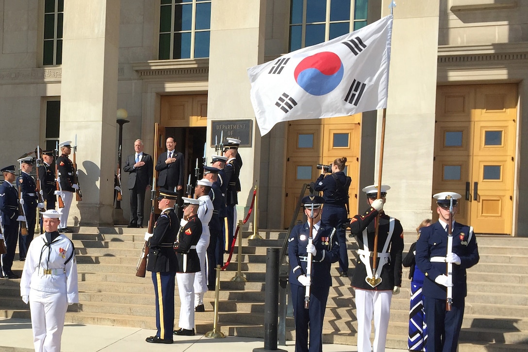Two defense leaders stand on the steps of the Pentagon.