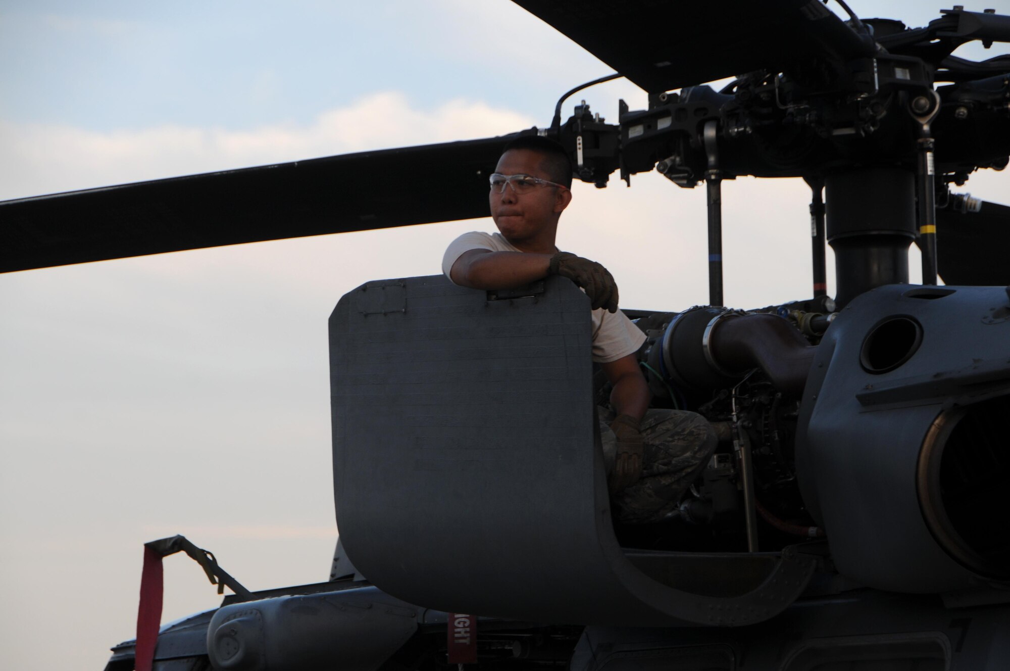 Air Force Senior Airman Ray-Christian Demafiles, a crew chief with the 106th Rescue Wing assigned to the New York Air National Guard, seated on top of an HH-60 Pavehawk helicopter engine cowling at Fort Hood, Texas August 28, 2017. The Pavehawk had returned from the day's mission that helped save 255 people and two dogs. (U.S. Air National Guard photo by Daniel H. Farrell)