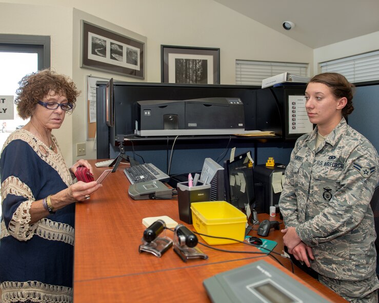 Jennifer Serex-Helwig receives the first Gold Star Defense Biometric Identification System installation access ID card issued at Travis Air Force Base, Calif., from U.S. Air Force Senior Airman Kiersten Porowski, 60th Security Forces Squadron, Aug. 29, 2017. Serex-Helwig is the daughter of U.S. Air Force Lt. Col. Henry Serex whose plane was shot down over Vietnam on April 2, 1972 and has been missing-in-action ever since. The Gold Star DBIDS installation access card is a Chief of Staff of the Air Force initiative which allows family members of those who perished in combat or as a result of a terrorist incident, to obtain an ID card. (U.S. Air Force photo by Louis Briscese)