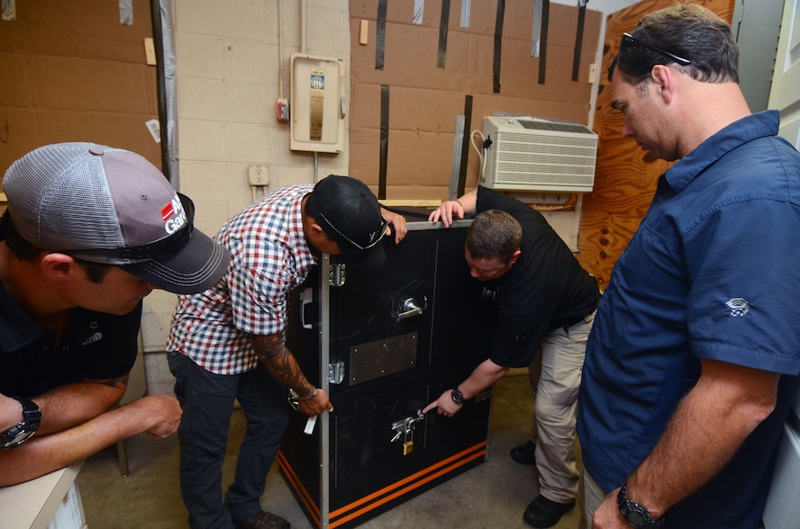 An evaluator points to a padlocked cabinet door and provides feedback after a training scenario to this year's Eastern National Robot Rodeo participants at Dobbins Air Reserve Base, Ga. on Aug. 23, 2017. The scenario tested the team's ability to open a variety of locked cabinet doors. (U.S. Air Force photo/Don Peek)
