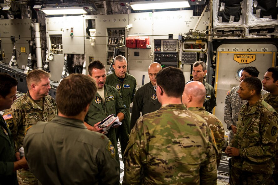 U.S. Air Force C-17 Pilot Maj. Chance Harridge/317th Airlift Squadron briefs U.S. Army Airborne soldiers with the 4th Quartermaster Company, 725 Brigade Support Battalion on the upcoming jump. Photo taken by U.S. Air Force Staff Sgt. Garrett Wake on 24 August, 2017. (U.S. Air Force Photo / Staff Sgt. Garrett Wake)