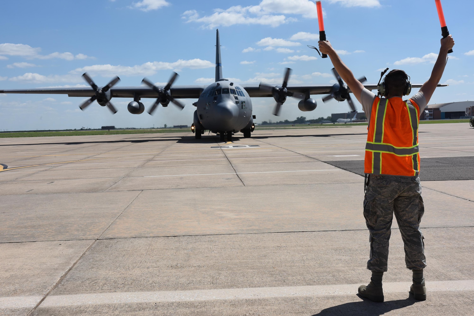 A 137th air field manager from the 137th Special Operations Wing, Will Rogers Air National Guard Base in Oklahoma City, marshals a C-130 Hercules from the 136th Airlift Wing, Naval Air Station Fort Worth Joint Reserve Base at Carswell Field, Texas, as they take off from Will Rogers Air National Guard Base, Aug. 28, 2017. The 137th Special Operations Wing deployed nearly 40 medical and aeromedical evacuation Airmen and equipment in support of the Texas Military Department and their relief efforts following Hurricane Harvey. (U.S. Air National Guard photo by Staff Sgt. Kasey Phipps/Released)
