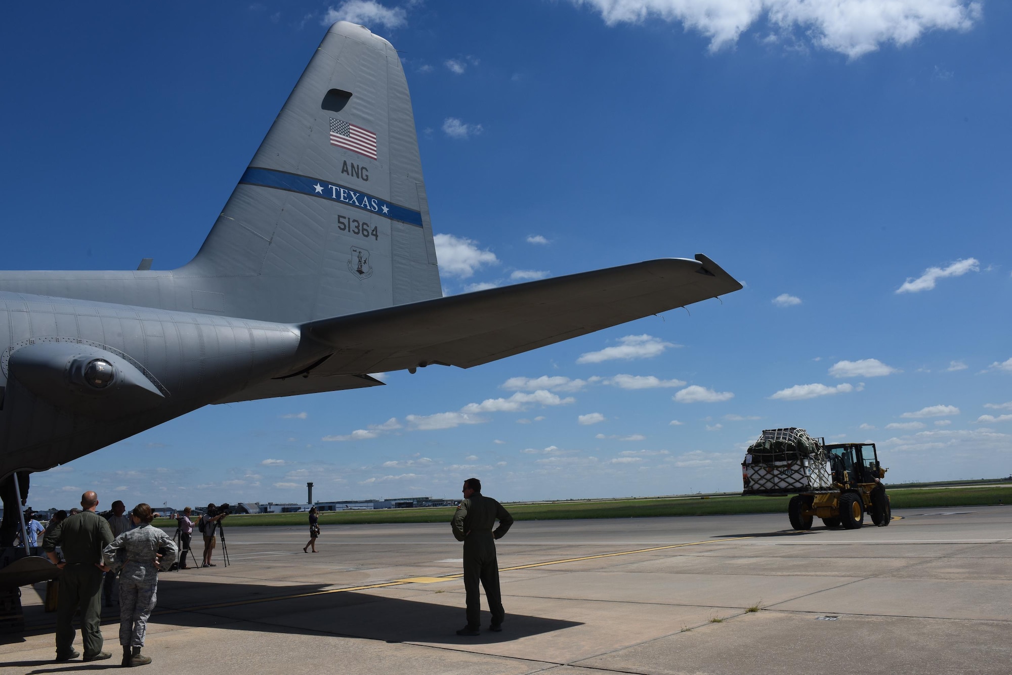 Airmen from the 137th Special Operations Wing, Will Rogers Air National Guard Base, Oklahoma City, and the 136th Airlift Wing from Naval Air Station Fort Worth Joint Reserve Base at Carswell Field, Texas, wait as a second pallet of medical equipment and supplies from the 137th is loaded onto a C-130 Hercules from the 136th, Aug. 28, 2017, at Will Rogers Air National Guard Base. The 137th Special Operations Wing deployed nearly 40 medical and aeromedical evacuation Airmen and equipment in support of the Texas Military Department and their relief efforts following Hurricane Harvey. (U.S. Air National Guard photo by Staff Sgt. Kasey Phipps/Released)