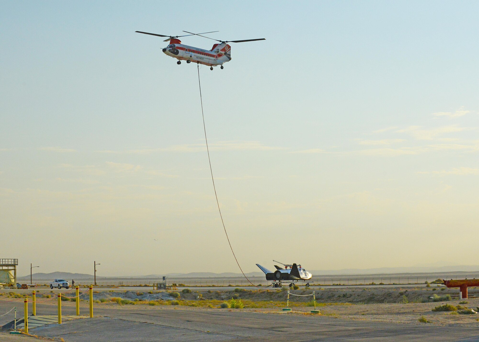 A Columbia Helicopters Model 234-UT Chinook helicopter carries the Dream Chaser over Edwards for a captive carry test Aug. 30. The test was part of the spacecraft’s Phase Two flight test efforts to advance the orbiter closer to space flight. (U.S. Air Force photo by Kenji Thuloweit)