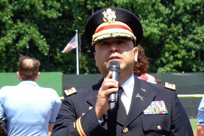a soldier stands with a microphone and sings.