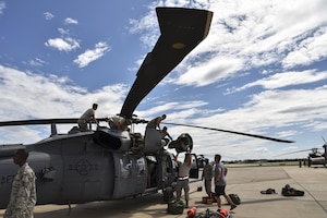 Airmen prepare a Pave Hawk helicopter for a rescue mission