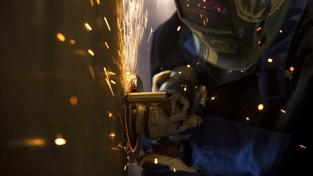 An airman removes a piece of metal at the metals technology shop.