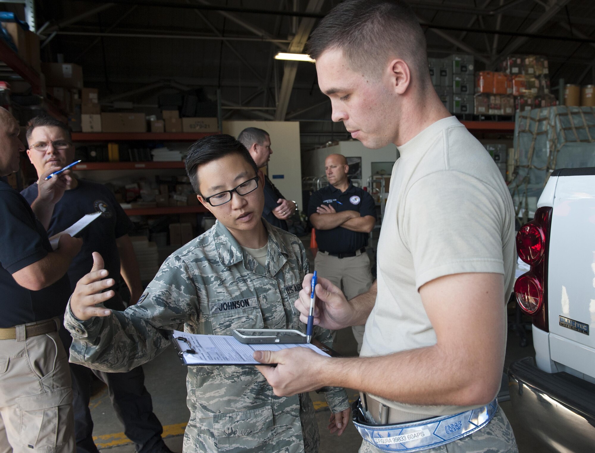 Base, Calif., check over a form during a during a joint inspection training and practical demonstration performance evaluation Aug. 23, 2017, McClellan Park, Calif.The annual inspection is designed to help members of the California Urban Search and Rescue Task Force 7 team to learn about the JI process, governing directives and ensuring that cargo is safe before loading onto an aircraft. (U.S. Air Force photo/ Heide Couch)