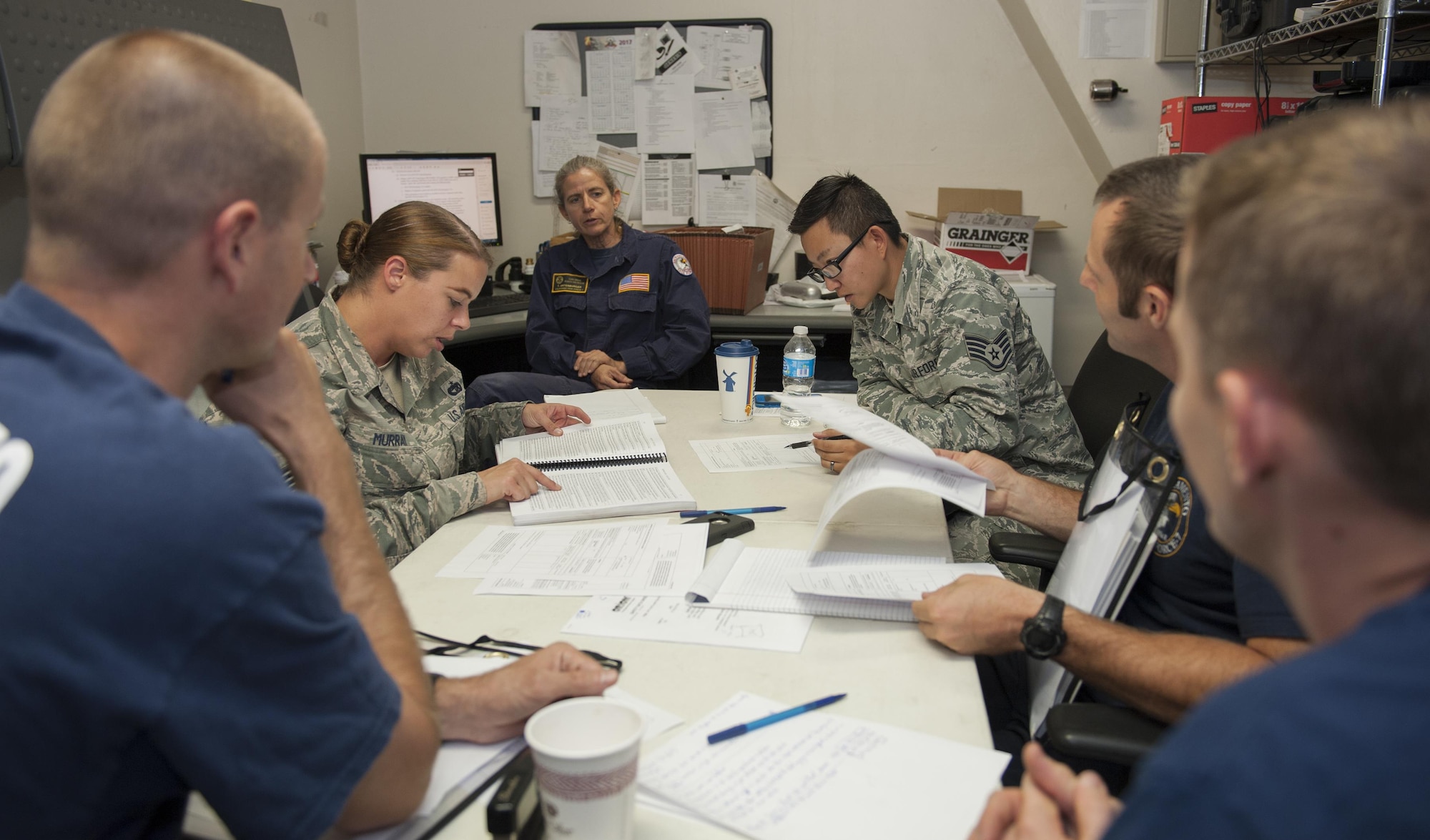 U. S. Air Force Tech. Sgt. Stacey Murray (center left) and Staff Sgt. Leah Johnson, (center right) 60th Aerial Port Squadron, review regulations regarding hazardous cargo with members of the California Urban Search and Rescue Task Force 7 during a joint inspection training and practical demonstration performance evaluation conducted by Airmen from the 60th APS, Travis Air Force Base, Calif., Aug. 23, 2017, at McClellan Park, Calif. The annual inspection helps members of the CA TF-7 team to learn about the JI process, governing directives and ensuring that cargo is safe before loading onto an aircraft. (U.S. Air Force photo/ Heide Couch)