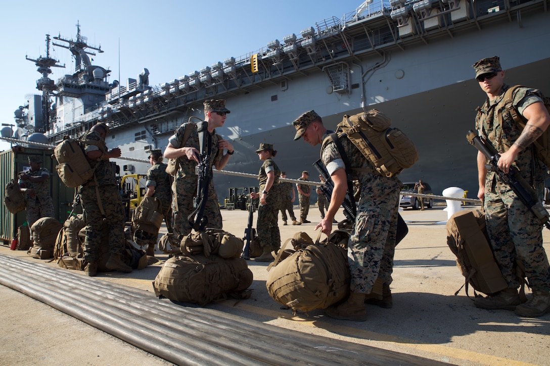 Marines from Combat Logistics Battalion 26, stationed at Marine Corps Base Camp Lejeune, N.C.. stage their packs on the dock at Naval Operations Base Norfolk  as they prepare to load LHD-3, Aug. 30. The Marines and sailors of CLB 26 spent the day loading the ship with heavy equipment and other gear in order to provide relief support to Texas citizens who were impacted by Hurricane Harvey. (Official Marine Corps Photo by Master Sgt. Ryan O’Hare/Released)
