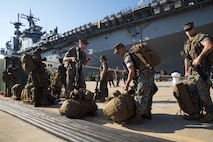 Marines from the 26th Marine Expeditionary Unit, stationed at Marine Corps Base Camp Lejeune, N.C.. stage their packs on the dock at Naval Operations Base Norfolk  as they prepare to load LHD-3, Aug. 30. The Marines and sailors of the 26th MEU spent the day loading the ship with heavy equipment and other gear in order to provide relief support to Texas citizens who were impacted by Hurricane Harvey. (Official Marine Corps Photo by Master Sgt. Ryan O’Hare/Released)