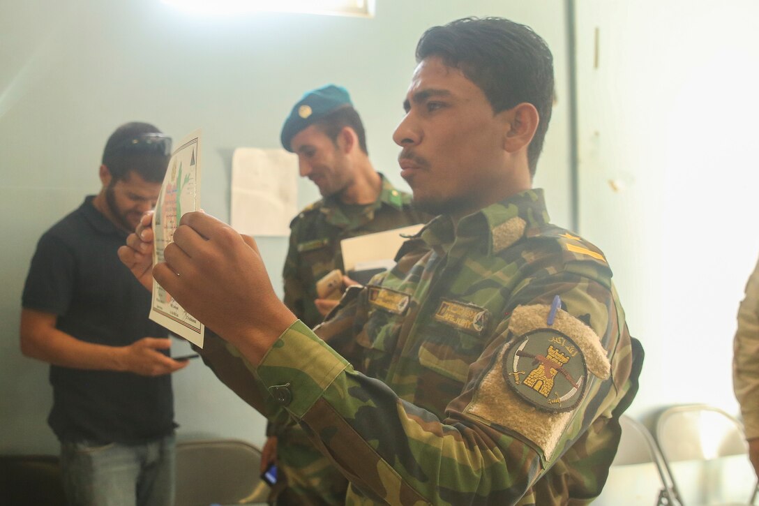 An Afghan National Army soldier displays his certificate of completion during a graduation ceremony at Camp Shorabak, Afghanistan, Aug. 30, 2017. Approximately 70 soldiers with various units from within 215th Corps completed an eight-week route clearance course led by U.S. advisors. The training focused on enhancing the soldiers’ abilities to locate and clear improvised explosive devices, execute proper minesweeping techniques and conduct mounted clearance in Mine-Resistant Ambush Protected vehicles. (U.S. Marine Corps photo by Sgt. Lucas Hopkins)