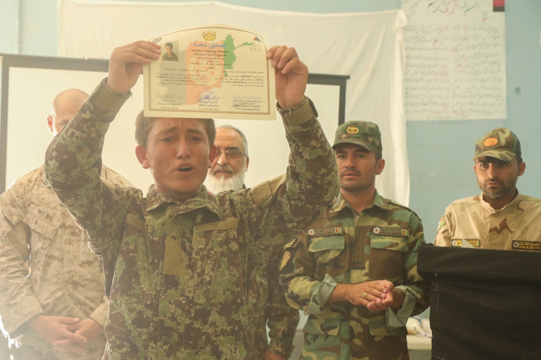 An Afghan National Army soldier displays his certificate of completion during a graduation ceremony at Camp Shorabak, Afghanistan, Aug. 30, 2017. Approximately 70 engineer soldiers with various units from 215th Corps graduated from a route clearance course, which was led by U.S. advisors. The curriculum focused on developing the Afghan’s tactics and procedures when locating and clearing improvised explosive devices and mines, helping to improve mobility of troops and supplies on the battlefield. (U.S. Marine Corps photo by Sgt. Lucas Hopkins)