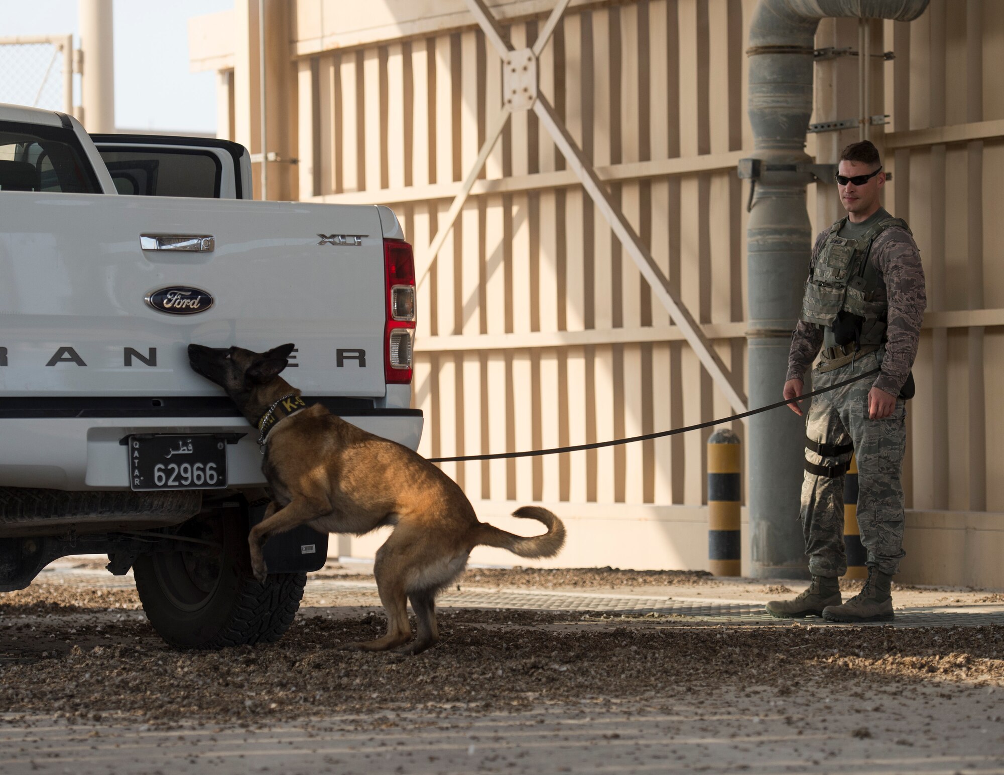 U.S. Air Force Staff Sgt. Timothy Dawson, a military working dog handler and his military working dog Mmaura both with the 379th Expeditionary Security Forces Squadron, and search a vehicle at Al Udeid Air Base, Qatar, Aug. 26, 2017.