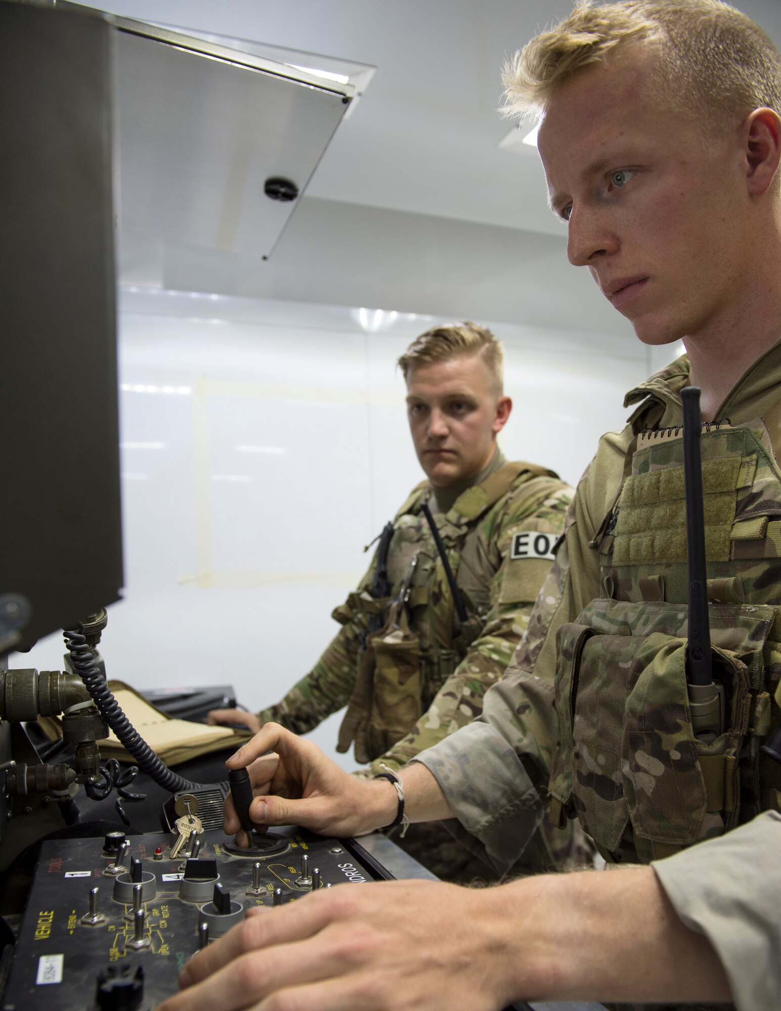 U.S. Air Force Senior Airman Luke Bryant, right, a team member and robot operator with the 379th Expeditionary Civil Engineer Squadron Explosive Ordnance Disposal Flight, controls a Remotec ANDROS F6A heavy-duty robot during a vehicle search exercise at Al Udeid Air Base, Qatar, Aug. 26, 2017.