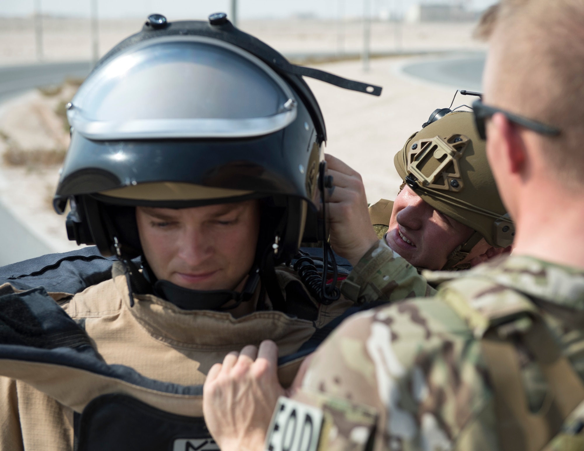Staff Sgt. Weston Cobb, team member with the 379th Expeditionary Civil Engineer Squadron Explosive Ordnance Disposal Flight, back right, secures the helmet of Staff Sgt. Brian Vosper’s, team leader, at Al Udeid Air Base, Qatar, Aug. 26, 2017.