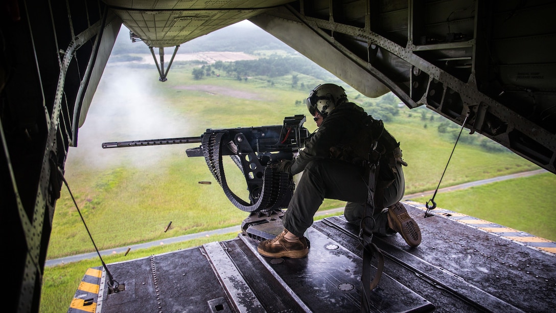 A crew chief fires a Browning M2 .50-caliber machine gun from the back of a CH-53E Super Stallion above Draughon Range near Misawa Air Base, Japan, August 21, 2017, in support of exercise Northern Viper 17. This combined-joint exercise is held to enhance regional cooperation between participating nations to collectively deter security threats. The crew chief is assigned to Marine Heavy Helicopter Squadron 462, Marine Aircraft Group 16, 3rd Marine Aircraft Wing, currently forward deployed under the Unit Deployment Program with Marine Aircraft Group 36, 1st MAW, based out of Okinawa, Japan.  (U.S. Marine Corps photo by Lance Cpl. Andy Martinez)
