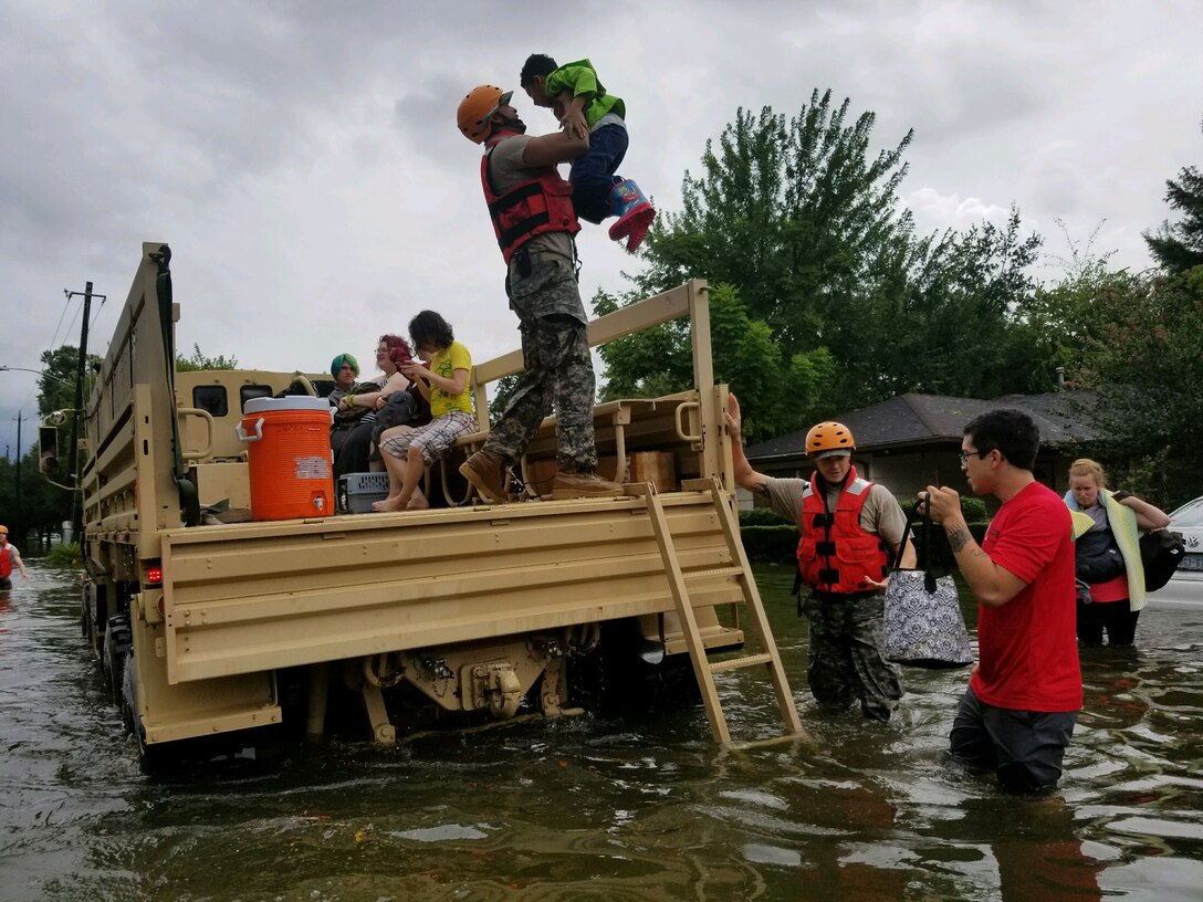 Military truck in flooded street with victims in/around truck bed