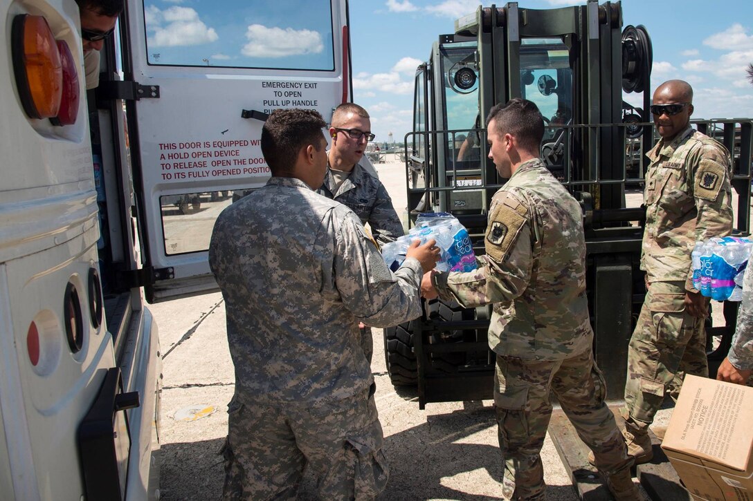 Military members loading supplies into vehicle