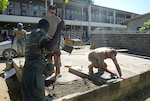 Soldiers from the South Dakota Army National Guard and members of Suriname Defense Force repair a concrete foundation while renovating portions of the O.S. Majosteeg 3 School in Paramaribo, Aug. 13-24