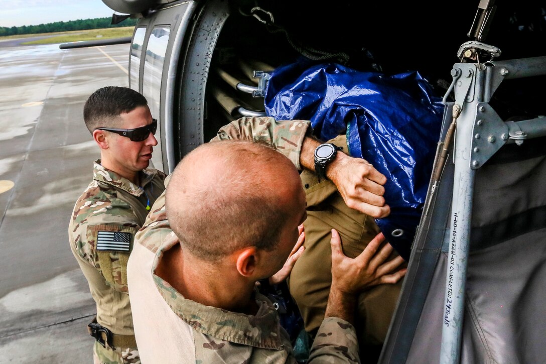 New Jersey Air National Guardsmen load gear onto a UH-60 Black Hawk helicopter.