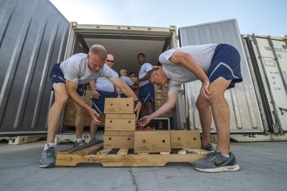 Brig. Gen.Derek C. France, left, 380th Air Expeditionary Wing commander, and Col. Mark S. Robinson, 380 AEW vice commander,  unload pallets of food Aug. 31, 2017, at Al Dhafra Air Base, United Arab Emirates.