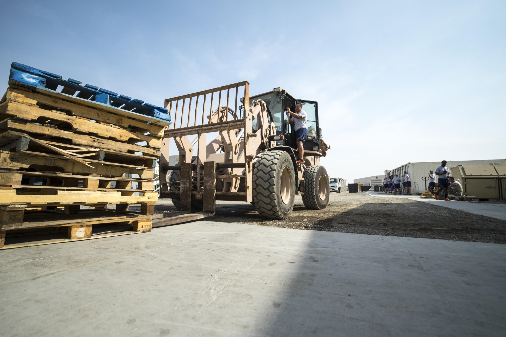 Brig. Gen. Derek C. France, 380th Air Expeditionary Wing commander, moves empty pallets under the guidance of Airman 1st Class Cristian Narino Garcia, 380th Expeditionary Force Support Squadron services journeyman, Aug. 31, 2017, at Al Dhafra Air Base, United Arab Emirates.