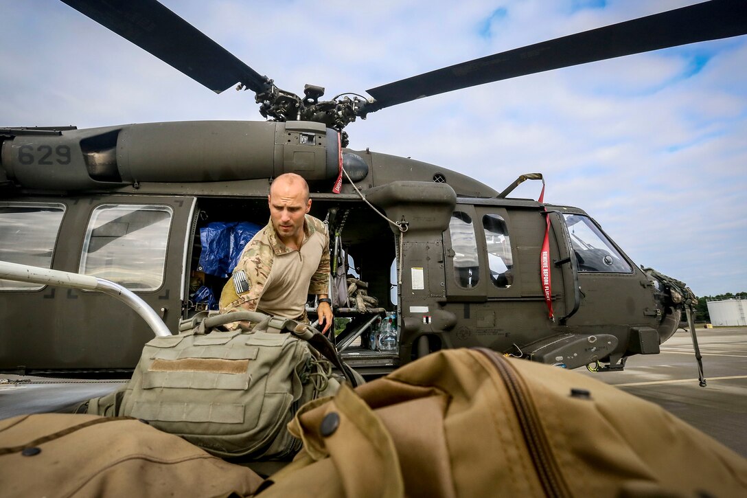 Staff Sgt. Robert Hawlik loads gear onto a UH-60 Black Hawk helicopter.