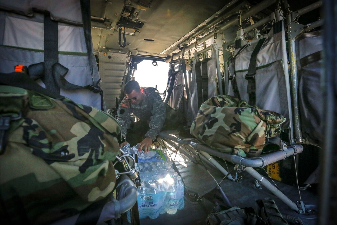 Sgt. Ralph Foy loads gear onto a UH-60 Black Hawk helicopter.