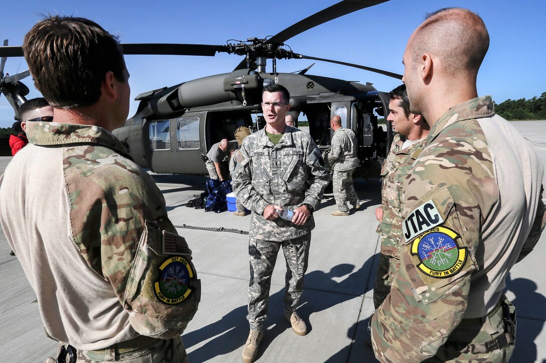 Army Chief Warrant Officer II Bryan Breza, center, briefs Air National Guard tactical control party airmen