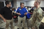Daniel Green (left), an external affairs officer with Federal Emergency Management Agency’s Region VIII Incident Management Assistance Team, Garth MacDonald (center), a public information officer with U.S. Small Business Administration, and Cpt. Anthony Hartman (right) , a U.S. Army North (Fifth Army) engineer augmentee to Region VI, discuss integration between local, state and federal assets supporting people affected by Tropical Storm Harvey Aug. 29 in Austin, Texas.