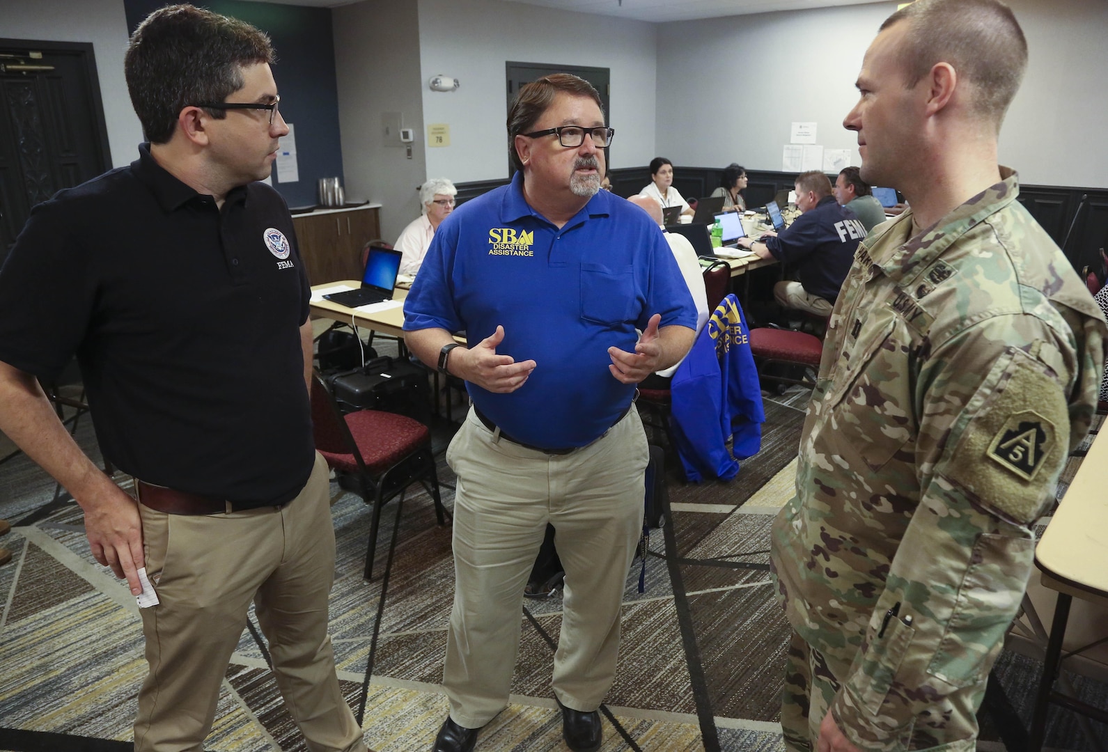 Daniel Green (left), an external affairs officer with Federal Emergency Management Agency’s Region VIII Incident Management Assistance Team, Garth MacDonald (center), a public information officer with U.S. Small Business Administration, and Cpt. Anthony Hartman (right) , a U.S. Army North (Fifth Army) engineer augmentee to Region VI, discuss integration between local, state and federal assets supporting people affected by Tropical Storm Harvey Aug. 29 in Austin, Texas.