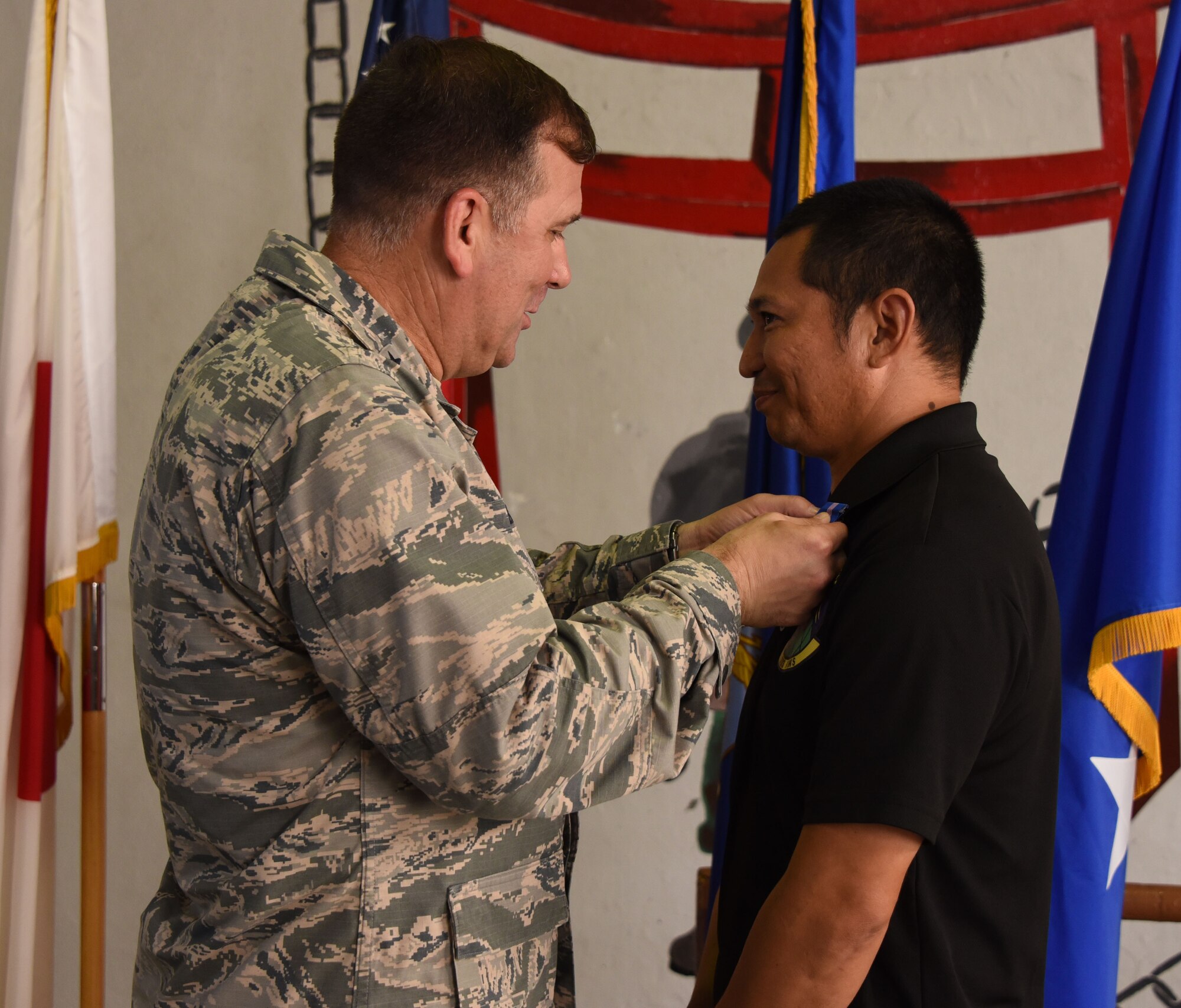 Maj. Gen. Christopher Bence, commander, USAF Expeditionary Center, awards the Army Achievement Medal to Takahiro Namizato for his contributions to a joint, bi-lateral air load exercise with the 1st Battallion, 1st Air Defense Artillery Regiment during a ceremony at Kadena Air Base, Japan, Aug. 23, 2017. (U.S. Air Force photo by Tech. Sgt. Jamie Powell)