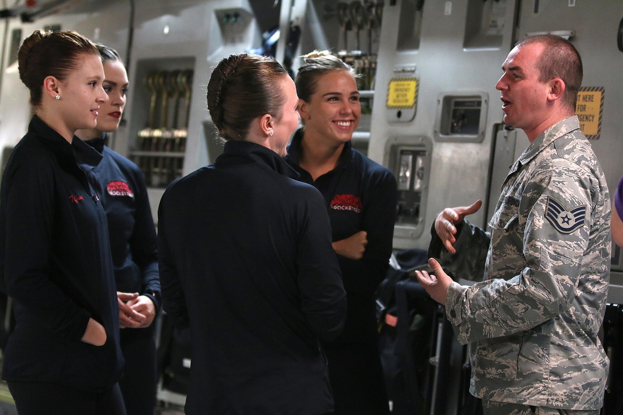 Staff Sgt. Rodney McElfresh, 445th Aircraft Maintenance Squadron crew chief, talks to members of the New York Rockettes about the mechanics of a C-17 Globemaster III during their tour of the aircraft August 22, 2017