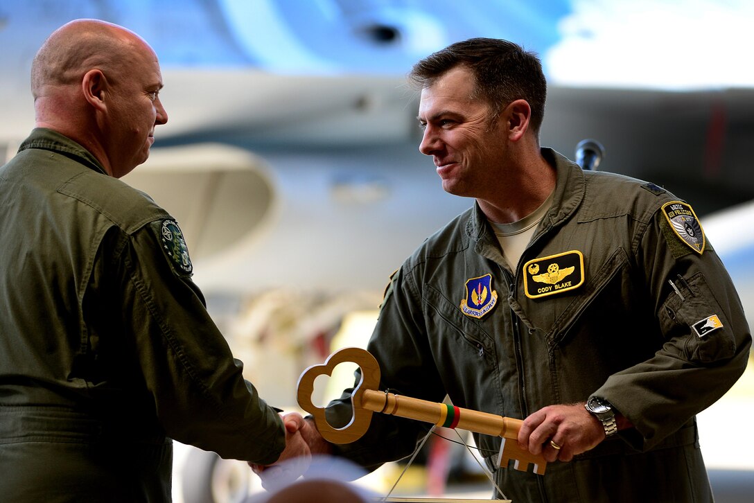 U.S. Air Force Lt. Col. Cody Blake, 493rd Expeditionary Fighter Squadron detachment commander, accepts the key to the Baltic Air Policing mission from Polish air force Lt. Col. Piotr Ostrouch during the official Baltic Air Policing hand-over, take-over ceremony at Šiauliai Air Base, Lithuania, Aug. 30, 2017. The 493rd EFS is slated to lead the Baltic Air Policing rotation through the end of the 2017 calendar year. (U.S. Air Force photo/ Tech. Sgt. Matthew Plew)