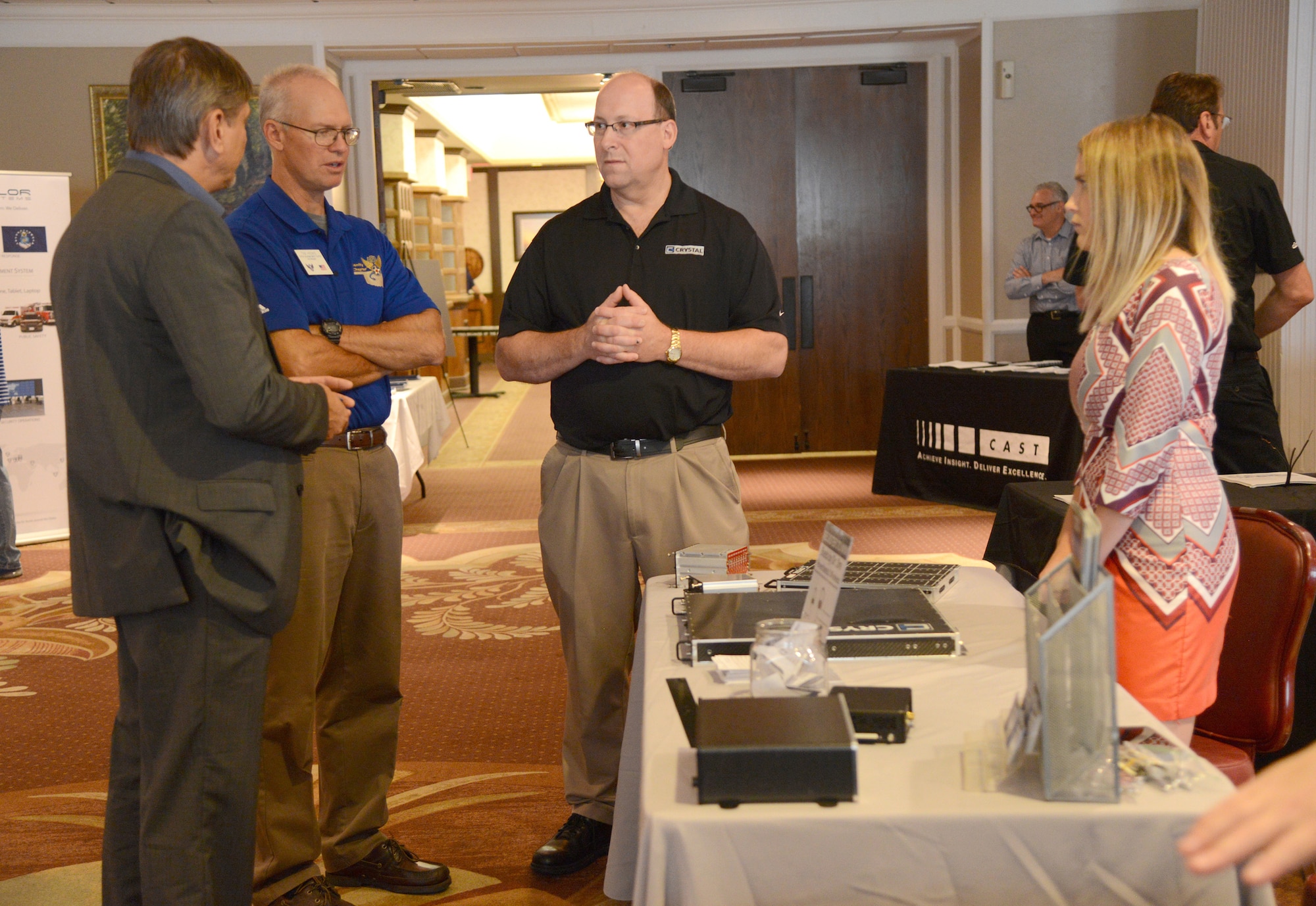Tim Henke, center left, with the Air Force Association's Gerrity Chapter, speaks with Todd Prouty, Brian Rinehart and Abbie Obermiller, representatives for Crystal Group Inc., during the 13th Annual Technology Day at the Tinker Club Aug. 17.