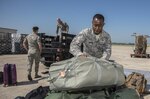 Airmen from the 59th Medical Wing readiness section load deployment bags for transport