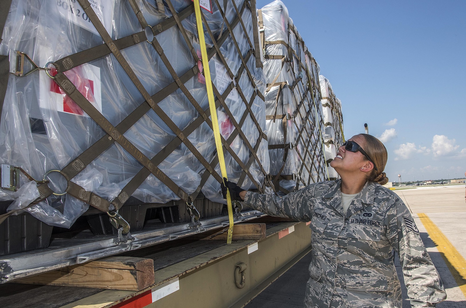 Staff Sergeant Paige Sanchez, 502nd Logistics Readiness Squadron, ensures pallets loaded with medical supplies and equipment are secure