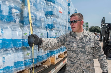 Staff Sergeant James Brush, 502nd Logistics Readiness Squadron, prepares for transport over 30,000 water bottles