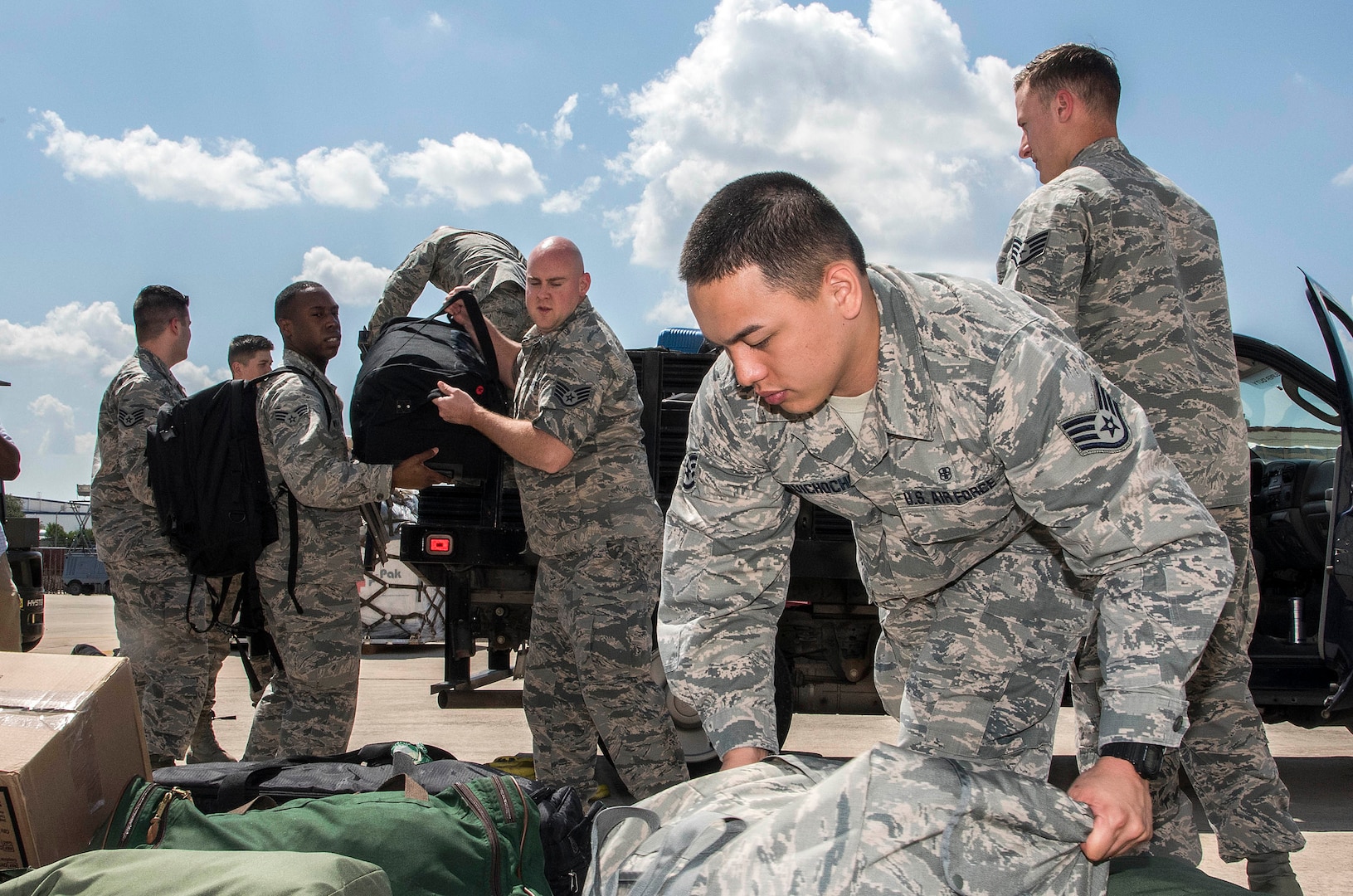 Airmen from the 59th Medical Wing prepare deployment bags for transport