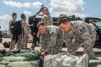 Airmen from the 59th Medical Wing prepare deployment bags for transport