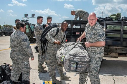 Airmen from the 59th Medical Wing prepare deployment bags for transport