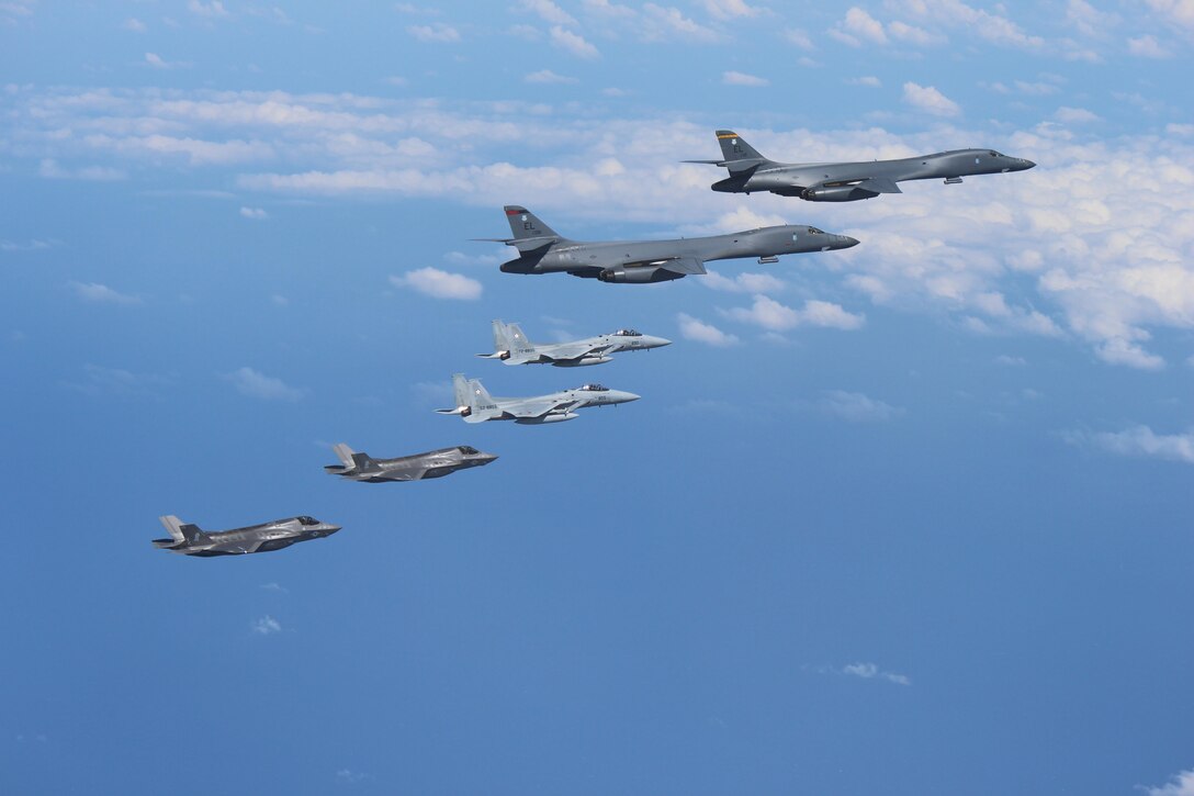 Marine Corps F-35B Lightning II stealth fighters assigned to the Marine Corps Air Station Iwakuni, Japan, fly alongside two Air Force B-1B Lancers assigned to the 37th Expeditionary Bomb Squadron, deployed from Ellsworth Air Force Base, South Dakota, over waters near Kyushu, Japan.