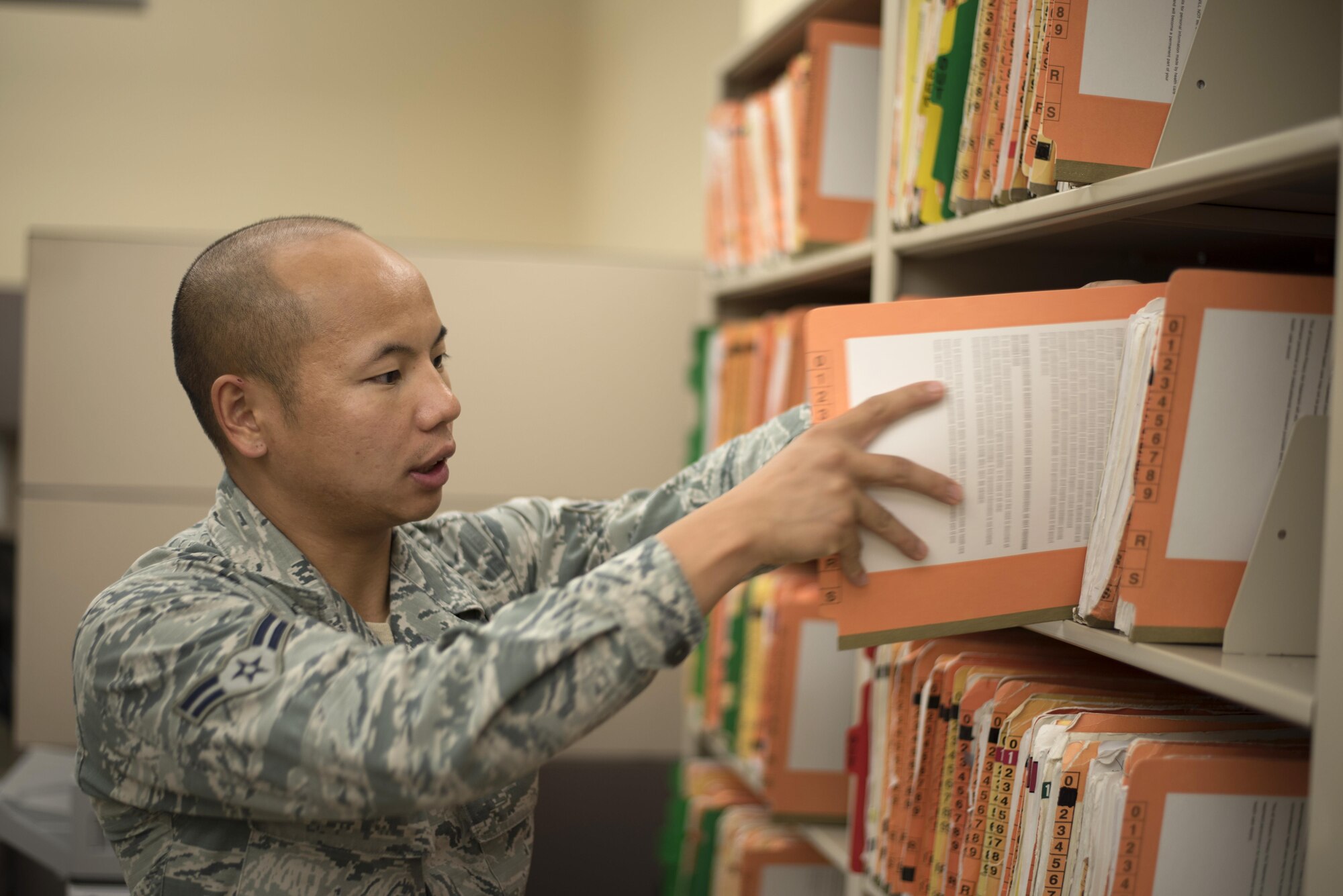 U.S. Air Force Airman 1st Class Seng Thao, a medical records technician assigned to the 6th Medical Support Squadron, puts a file back onto a shelf, Aug. 31, 2017, at MacDill Air Force Base, Fla.