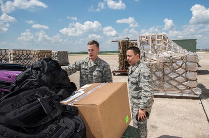 Airmen from the 59th Medical Wing prepare deployment bags for transport Aug. 30, 2017 at Joint Base San Antonio-Lackland, Texas.