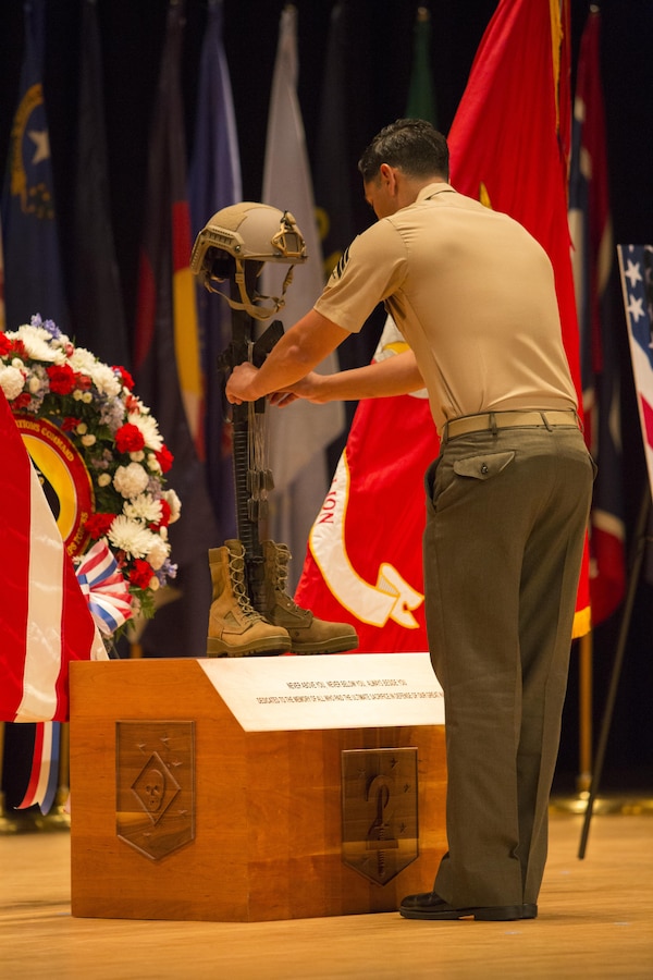 A critical skills operator with U.S. Marine Corps Forces, Special Operations Command, hangs the dog tags for one of seven fallen service members onto 2d Marine Raider Battalion’s soldier’s cross display at a celebration of life ceremony aboard Marine Corps Base Camp Lejeune, N.C., Aug. 31, 2017. Each person who spoke on behalf of one of the fallen service members, hung their respective dog tags onto the cross, which will be displayed at 2d MRB’s headquarters building. The ceremony honored the seven MARSOC service members lost July 10 in a KC-130T Hercules transport aircraft crash, including Staff Sgts. Robert Cox and William Kundrat, Navy special amphibious reconnaissance corpsman, Petty Officer 1st Class Ryan Lohrey , and Sgts. Chad Jenson, Dietrich Schmieman, Joseph Murray, and Talon Leach. (U.S. Marine Corps photo by Sgt. Salvador R. Moreno, released)