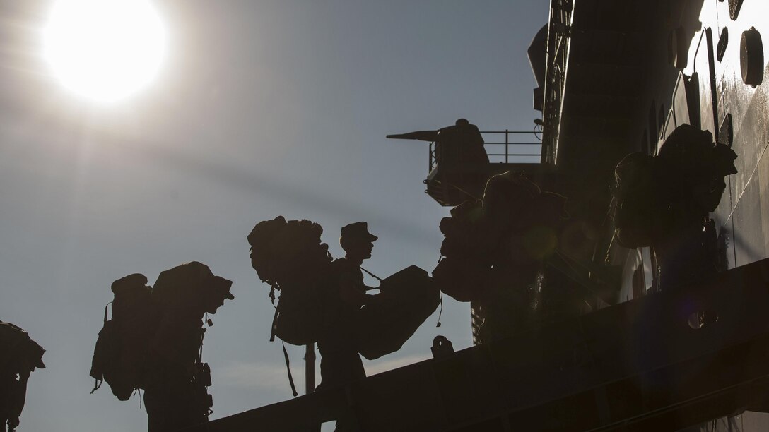 A group of Marines board a ship.