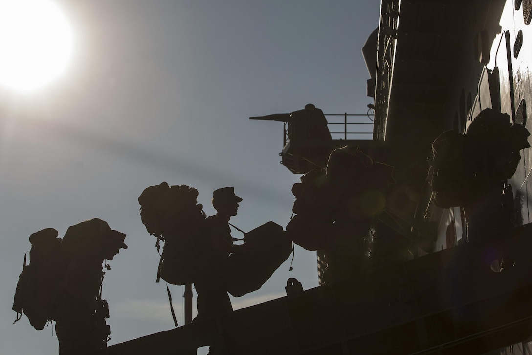 A group of Marines board a ship.